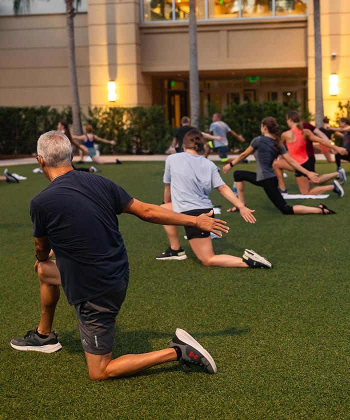 a group of people stretching on a grass field