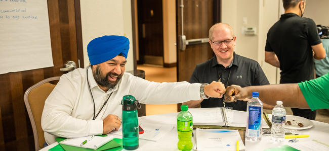 a group of men sitting at a table in a Propel class