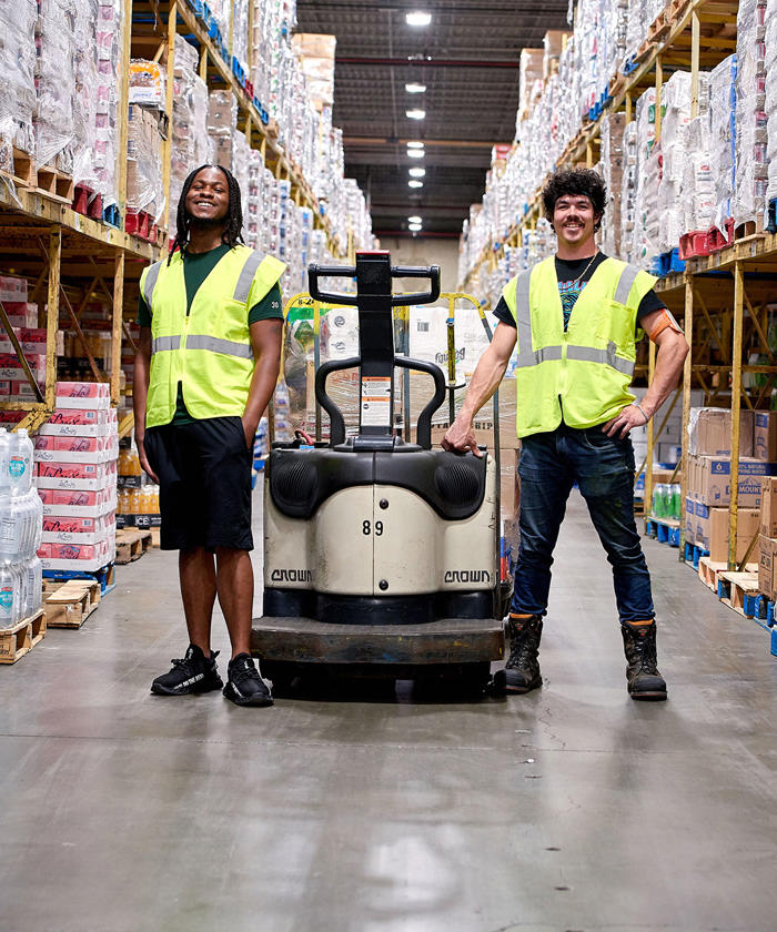 two men standing next to a forklift in a warehouse in our Omaha DC