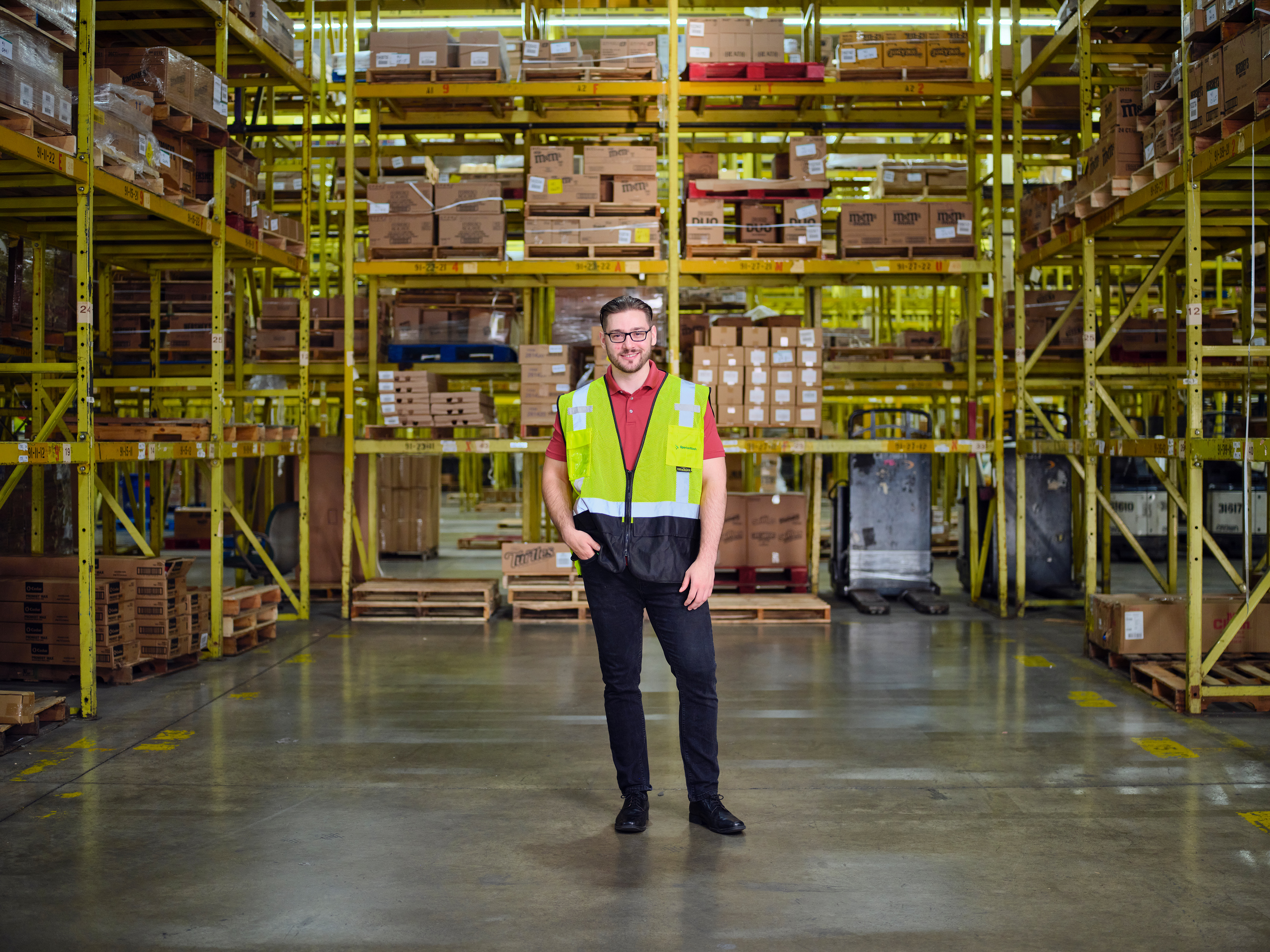 a man in a yellow vest in a warehouse
