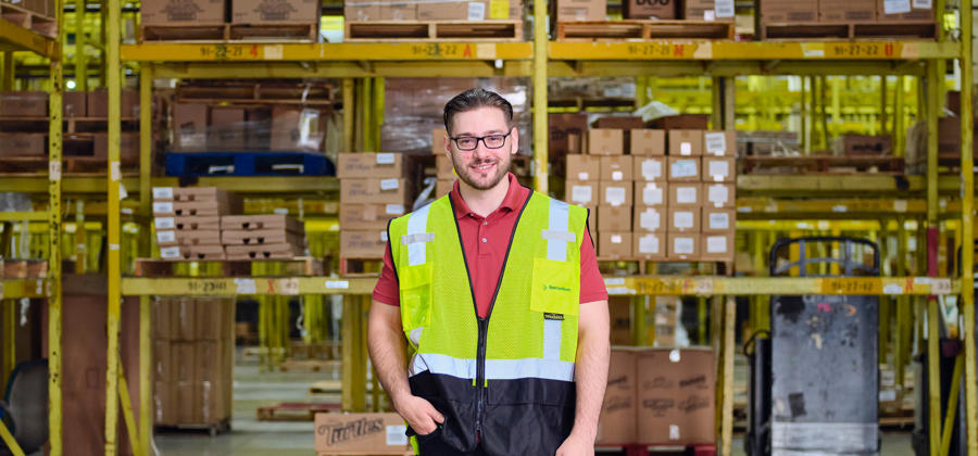 a man in a yellow vest in a warehouse