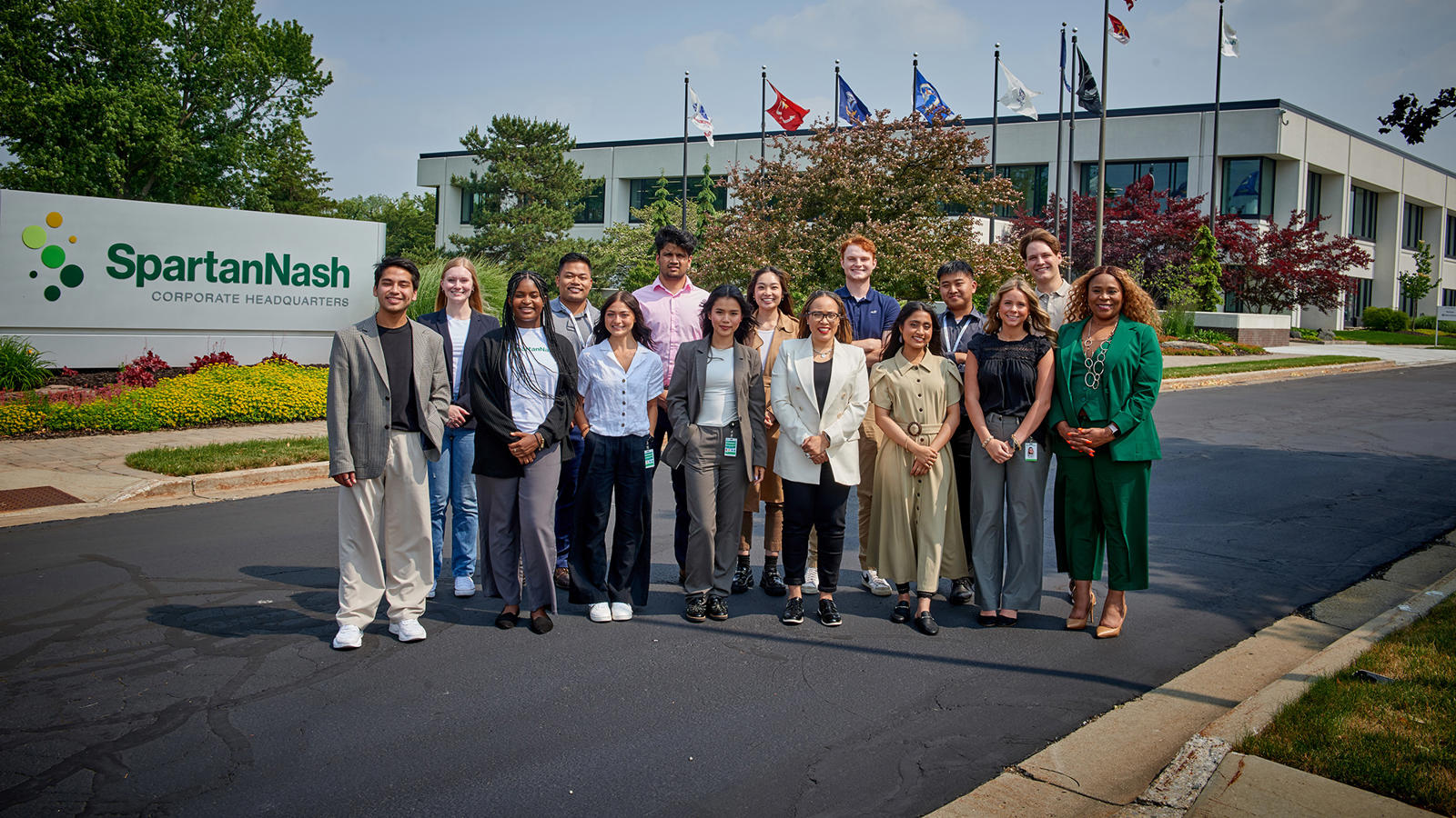 a group of interns standing in front of the corporate headquarters of SpartanNash