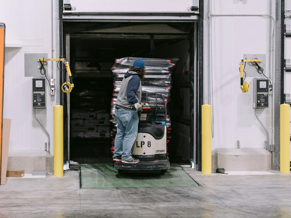 a man standing on a machine in a warehouse