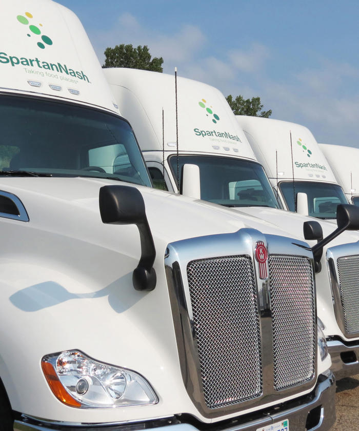 a row of white SpartanNash semi trucks