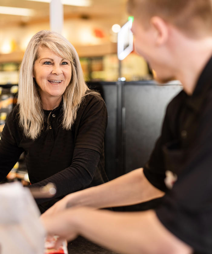 a woman smiling at a man in a grocery store