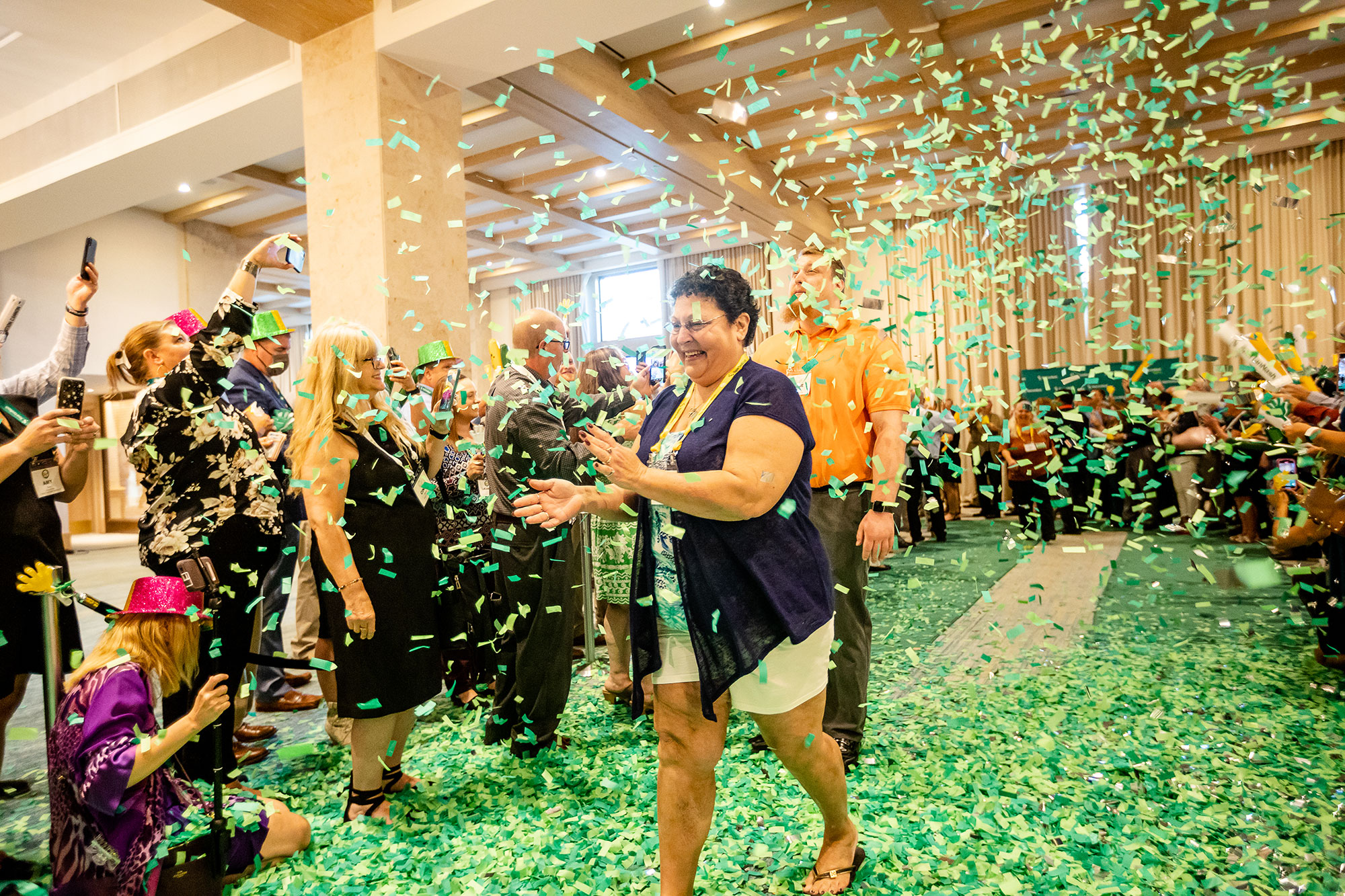 a woman throwing confetti in the air at a recognition event