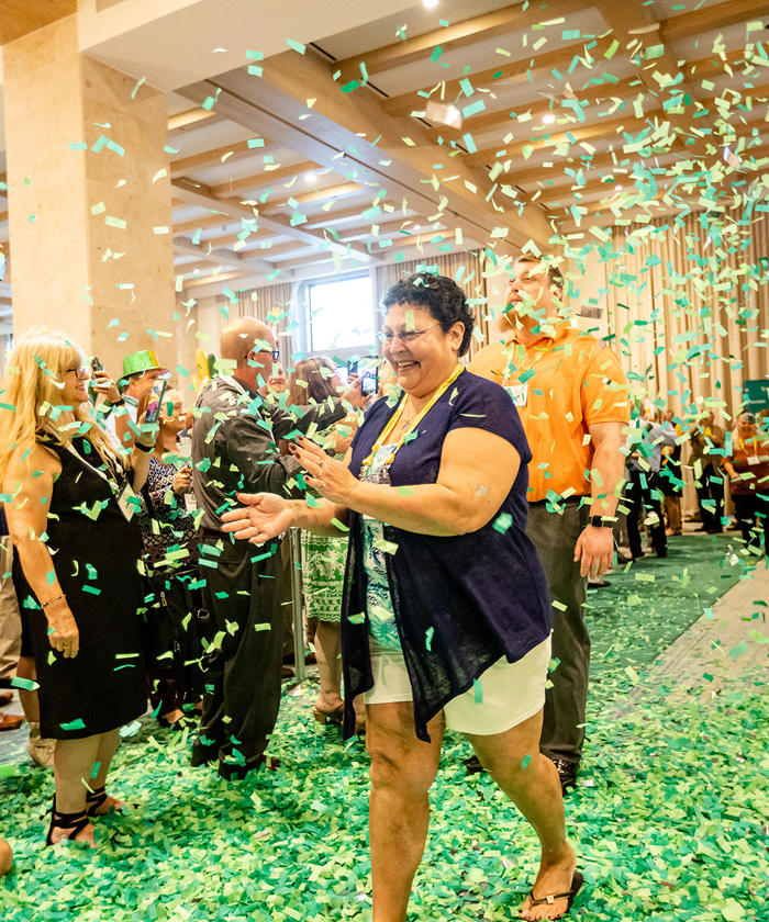 a woman throwing confetti in the air at a recognition event