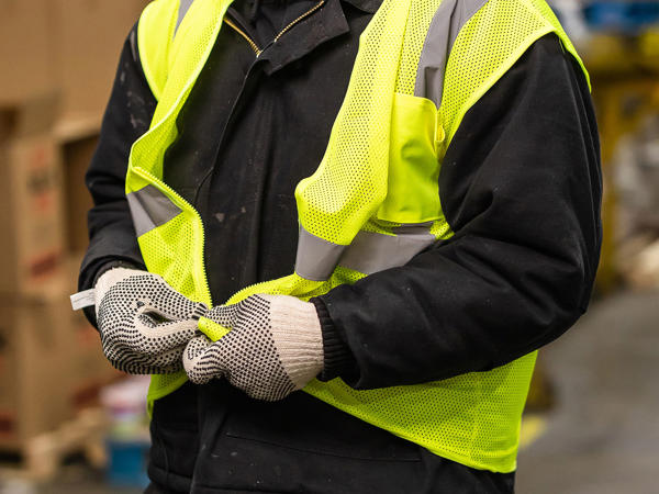 a person wearing a safety vest and gloves